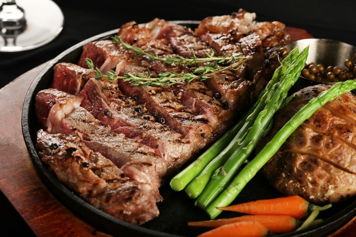 Pièce de bœuf grillée et tranchée, servie chaude sur son plat.