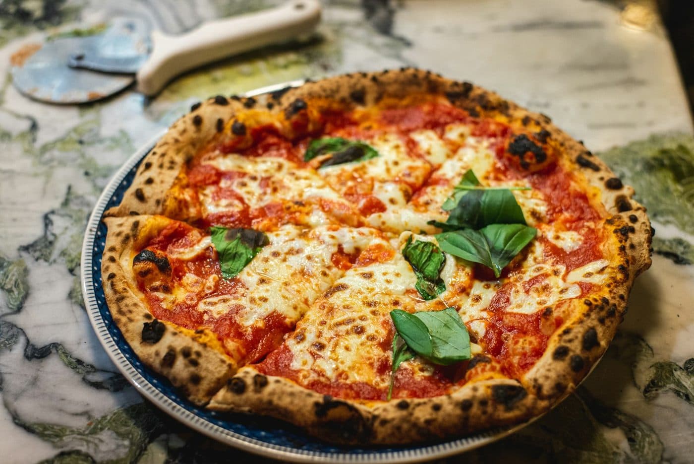 Pizza Margherita sortie du four, sauce tomate, mozzarella et basilic.